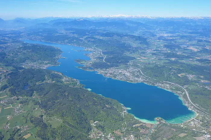 Wörthersee aus der Luft mit türkisem Wasser vor den Karawanken
